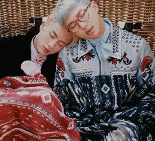Two Young Men Are Sleeping On A Wicker Couch With Their Heads On Each Other . GIF