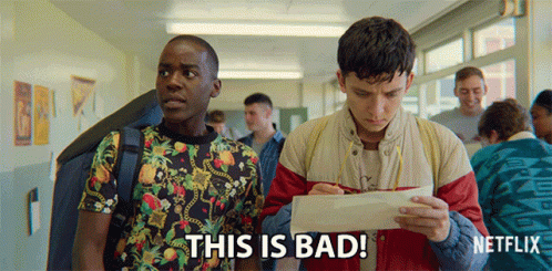 Two Young Men Are Standing In A Hallway And One Of Them Is Holding A Piece Of Paper That Says This Is Bad On It GIF