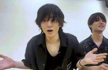 Two Young Men Are Standing Next To Each Other In A Room And One Of Them Is Making A Funny Face . GIF