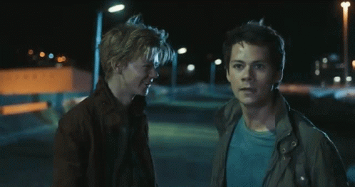 Two Young Men Are Standing Next To Each Other In The Dark GIF