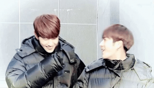 Two Young Men in Black Jackets Laughing