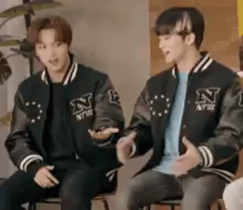 Two Young Men in Varsity Jackets Sitting
