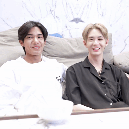Two Young Men on Couch, One in White Heart Shirt