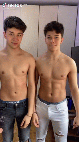 Two Young Men Without Shirts Standing Together GIF