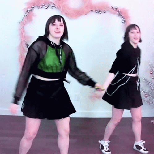 Two Young Women Dancing By Christmas Tree GIF