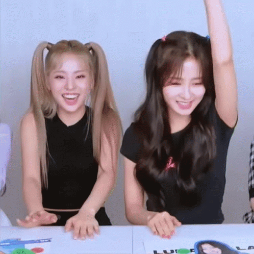 Two Young Women Raising Arms