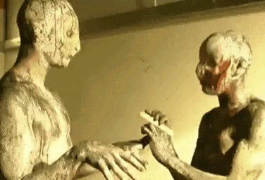 two zombies are standing next to each other in front of a mirror . one of the zombies is holding a knife .