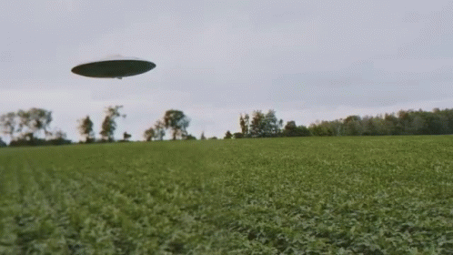 UFO Flying Over Grassy Field