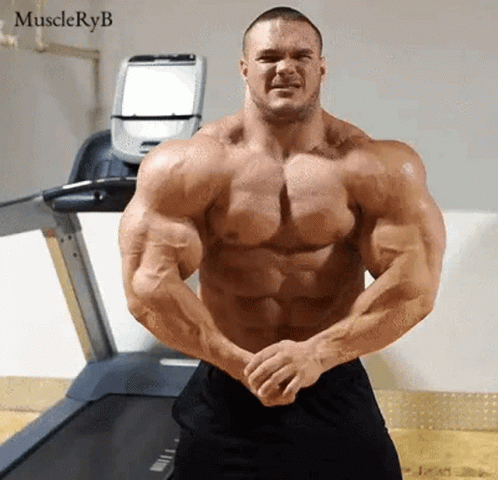 Very Muscular Man Standing in Front of Treadmill