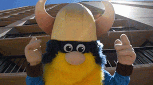 Viking Mascot Thumbs Up In Front Of Building GIF