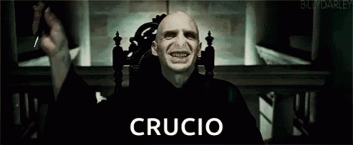 Voldemort From Harry Potter Is Sitting In A Chair With His Hands Up And The Word Crucio Written On His Face . GIF