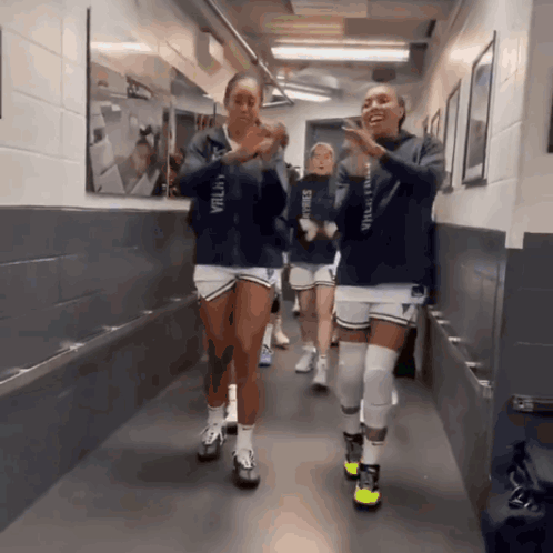 Volleyball Players Walking Down Hallway One Wearing Valley Hoodie GIF