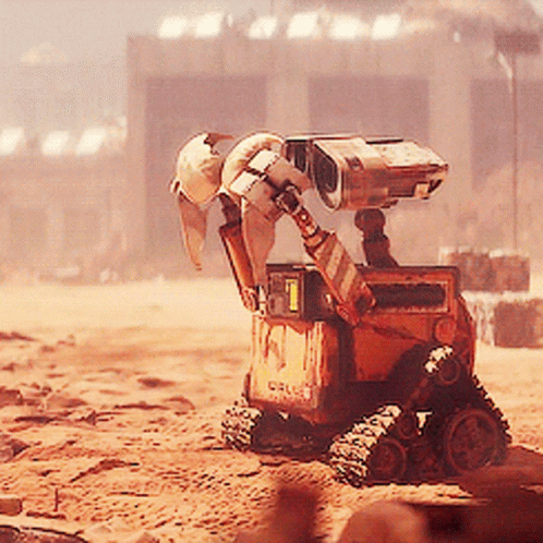 Wall E From The Movie Wall E Is Sitting In The Dirt GIF