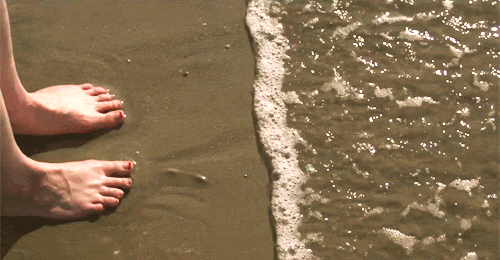 Bare Feet On The Sand While Waves Coming In GIF