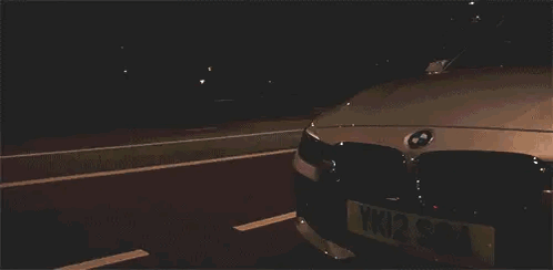 White BMW Parked in Dark Parking Lot