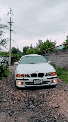 White BMW Parked on Gravel Road License Plate DZ-215