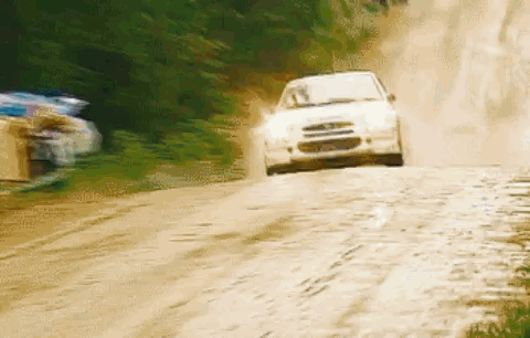 White Car Driving Down Dirt Road