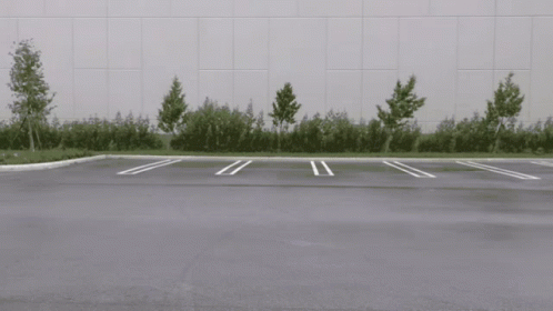 White Car Driving in Parking Lot