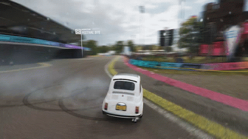 White Car Driving On Road Near Festival Site GIF