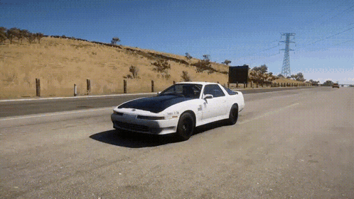 White Car Driving With License Plate Saying SNR