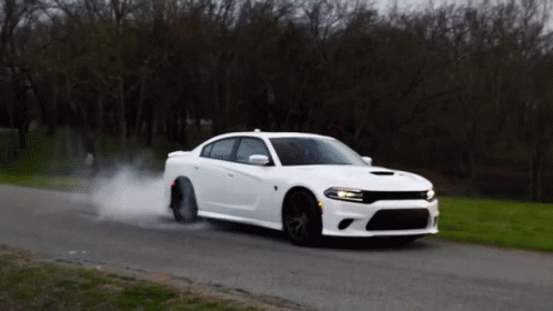 White Car Driving With Smoke From Tires