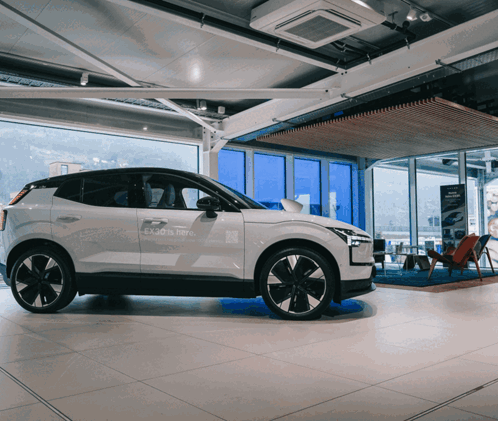 White Car In Showroom Saying Enjoy Is Here GIF