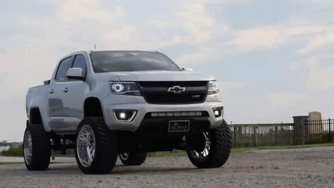 White Chevrolet Colorado Pickup Truck In Gravel Lot GIF