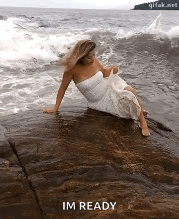 White-Dressed Woman on Ocean Rock Saying Im Ready