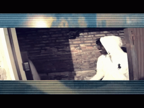 White Hoodie Man by Brick Wall and Door