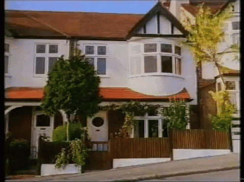 White House With Red Tile Roof and Wooden Fence