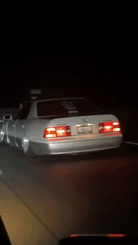 White Sports Car Parked in Dark Parking Lot at Night