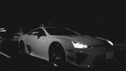 White Sports Car Parked in Dark Parking Lot at Night