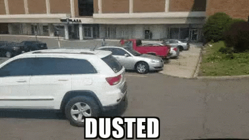 White SUV Parked Near Dusted Building GIF