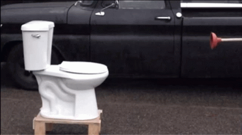 White Toilet On Wooden Pallet Next To Black Truck GIF