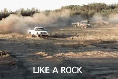 White Truck Driving Down Dirt Road Like a Rock