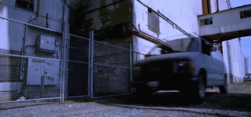 White Van Parked in Front of Chain Link Fence