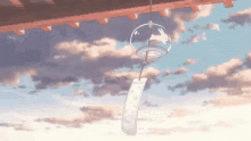 Wind Chime Hanging From Building Roof in Sky