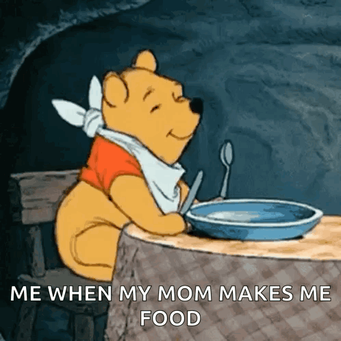 winnie the pooh sitting at a table with a bowl of food