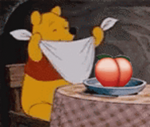 Winnie the Pooh Sitting at Table With Towel and Peach in Bowl