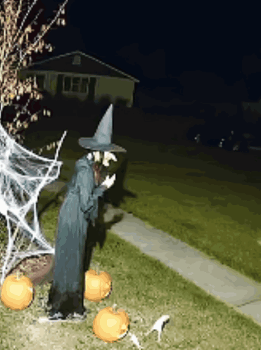 Witch Statue at House with Pumpkins and Spider Web