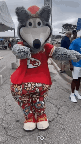 Wolf Mascot In Red Shirt And Floral Pants Standing On Street GIF