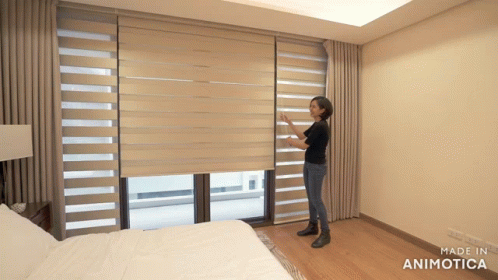 Woman Adjusting Blind In Bedroom GIF