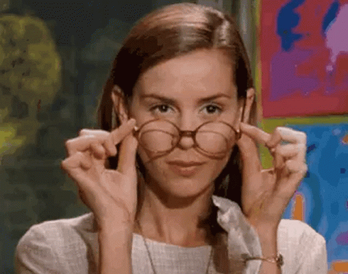 Woman Adjusting Glasses in Front of Painting