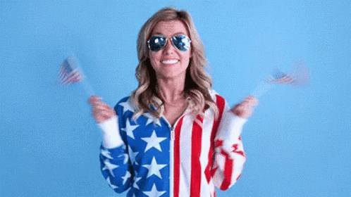 Woman American Flag Jacket Sunglasses Holding Two American Flags GIF