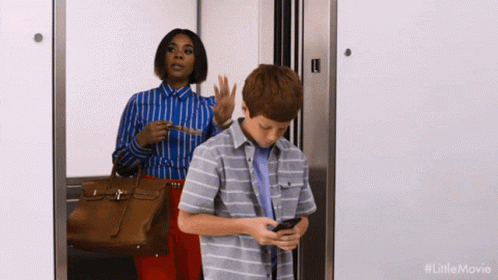 Woman and Boy in Elevator Boy Looking at Phone