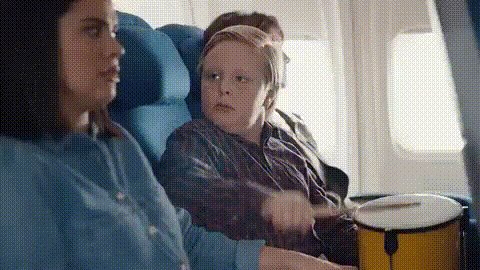 Woman And Boy Playing Drums On Airplane GIF