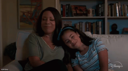 Woman and Girl Sitting on Couch Watching Disney+ Show
