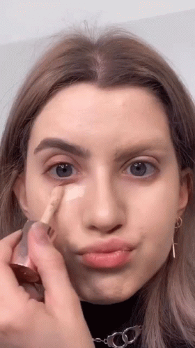 Woman Applying Foundation and Making Face