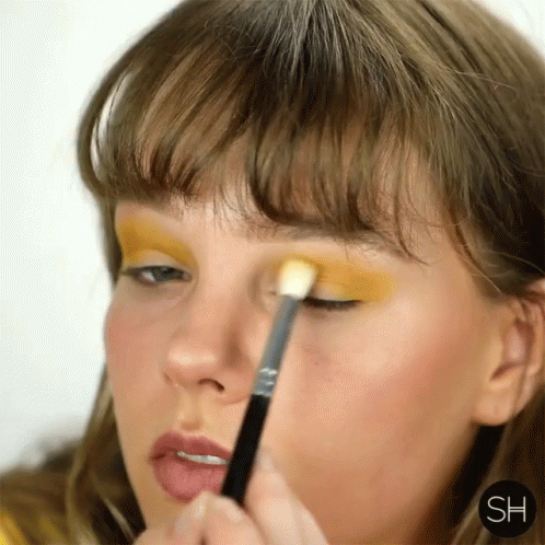 Woman Applying Yellow Eyeshadow With Brush