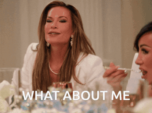 Woman at Table Saying What About Me